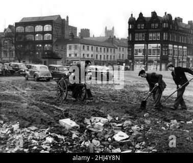 Bau des neuen Newcastle Civic Center im Haymarket-Gebiet von Newcastle upon Tyne, England. 14th. Dezember 1959. Mitarbeiter des Unternehmens, die auf dem Parkplatz auf dem neuen Rathausplatz in der Nähe der St. Thomas Church in Newcastle versuchen, den Schlamm mit Asche zu bedecken. Stockfoto