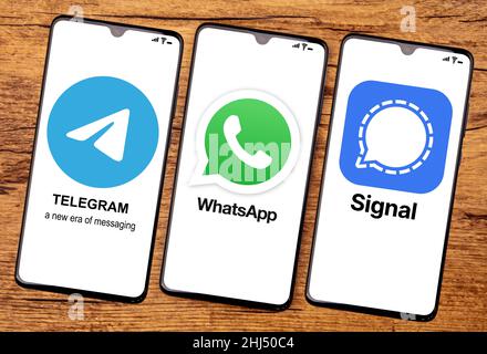 HUETTENBERG, DEUTSCHLAND 2021-12 14: TELEGRAM WHATSAPP und SIGNAL App auf dem Handy-Bildschirm. Draufsicht auf Holzhintergrund. Stockfoto