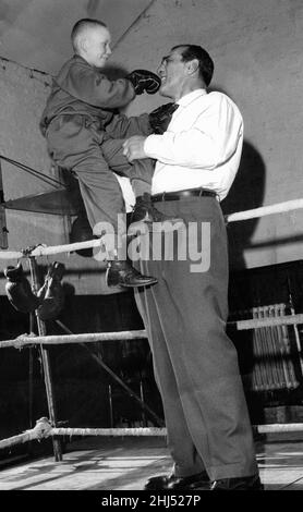 Primo Carnera, professioneller Wrestler, auch ehemaliger Profiboxer, bei der Eröffnung eines neuen Gymnasiums im Besitz von Les Caddick, in Collyhurst, Manchester, Montag, 21st. März 1960. Abgebildet ist die 10-jährige Leslie Caddick, Sohn des Motorenhändlers Les Caddick. Stockfoto