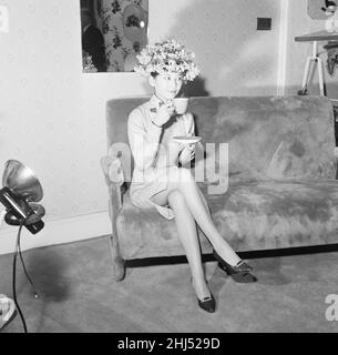 Tsai Chin, Schauspielerin und Hauptrolle in West End, spielt The World of Suzie Wong, im Prince of Wales Theatre, London, fotografiert Modelling Hats in Dolores, Großhandelsmüllern der Welbeck Street, Marylebone, London, 19th. November 1959. Unser Bild Zeigt ... Tsai Chin macht während der Dreharbeiten eine Pause, um eine Tasse Tee zu genießen. Stockfoto