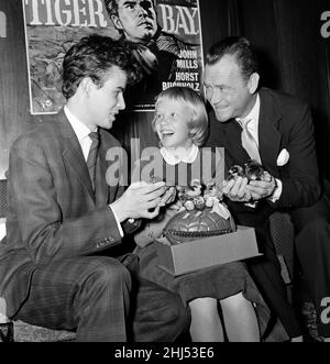 Die 12-jährige Schauspielerin Hayley Mills hält eine Pressekonferenz im Leicester Square Theatre ab, um ihren großen Erfolg im Film „Tiger Bay“ zu feiern. Sie ist mit ihren Mitspielern im Film, ihrem Vater John Mills (rechts) und Horst Buchholz abgebildet. 25th. März 1959. Stockfoto