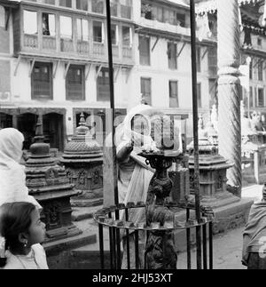 Eine Pilgerin sah hier, wie sie Kerzen in einem buddhistischen Stupa-Tempel in Kathmandu in Nepal anzündete. Februar 1961 l Stockfoto