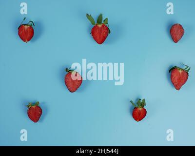 Frische Erdbeerscheiben auf blauem Hintergrund. Flach legen. Stockfoto
