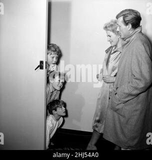 Der britische Sänger und Schauspieler Gary Miller und seine Frau Joy winken ihren Kindern, Jonty Pip und Kit, Auf Wiedersehen zu, als sie für den Abend ausgehen und Marjorie Proops sie als Babysitter überlassen.13th. April 1960. Stockfoto