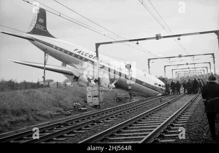 Das Wrack eines vollbeladenen Passagierflugzeugs Viscount, nachdem es die Start- und Landebahn am Rochford Airport übergeschossen hatte und auf der Bahnlinie, die am Flughafen entlang verläuft, landete. Feuerwehrmänner und Rettungsdienste machen den Passagieren den Weg frei, das Flugzeug zu verlassen. Oktober 1960. Stockfoto