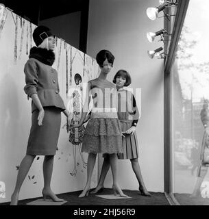 Mary Quant, Modedesignerin, steht im Fenster ihres Modehauses Bazaar, hier mit mehreren Puppen, die ihre zum Verkauf stehenden Designs tragen. Mary's Shop befindet sich in der Brompton Road, Knightsbridge, London, SW1 Aufnahme vom 14th. Oktober 1960 Stockfoto