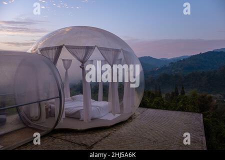 Glamping im Bubble Dome-Zelt in den Bergen von Chiang Mai Thailand, transparentes Glockenzelt mit komfortablem Bett und Kissen im Wald, Glamping-Hotel, Luxusreisen, glamouröses Camping. Stockfoto