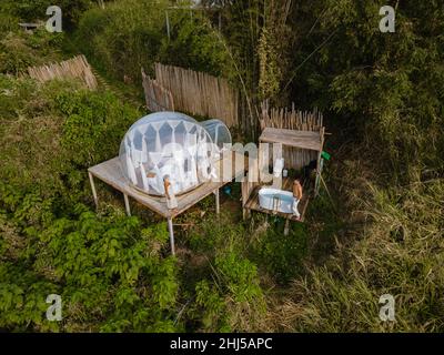 Glamping im Bubble Dome-Zelt in den Bergen von Chiang Mai Thailand, transparentes Glockenzelt mit komfortablem Bett und Kissen im Wald, Glamping-Hotel, Luxusreisen, glamouröses Camping. Stockfoto