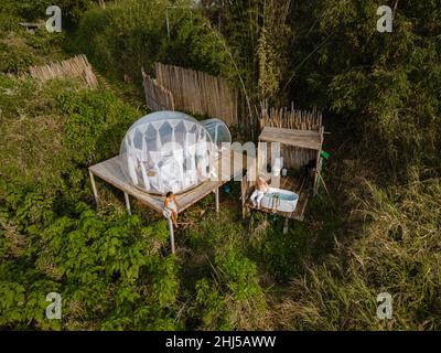 Glamping im Bubble Dome-Zelt in den Bergen von Chiang Mai Thailand, transparentes Glockenzelt mit komfortablem Bett und Kissen im Wald, Glamping-Hotel, Luxusreisen, glamouröses Camping. Stockfoto