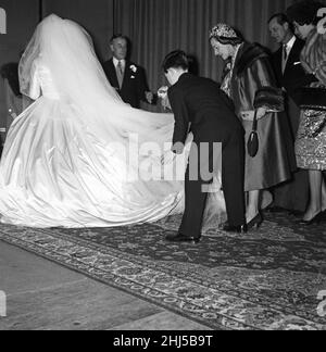 Die Hochzeit von Pamela Mountbatten und David Hicks in der Romsey Abbey, Hampshire. Prinz Charles unterstützt die Braut mit ihrem Kleid, beobachtet von Louis Mountbatten und Prinz Philip. 13th. Januar 1960. Stockfoto
