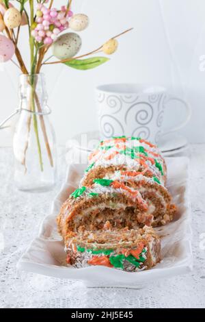 Karottenkuchengelee Rollen zu Ostern auf einer Platte vor weißem Hintergrund. Stockfoto