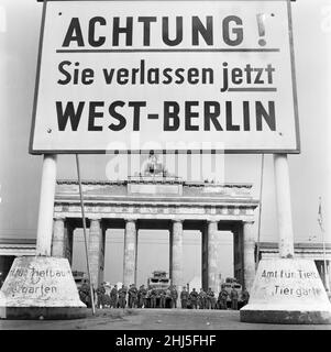 Beginn des Baus der Berliner Mauer.am 13th. August um Mitternacht begannen Polizei und Einheiten der DDR-Armee mit der Schließung der Grenze und am Sonntagmorgen, dem 13. August, wurde die Grenze zu West-Berlin geschlossen. Das Bild, das drei Tage später aufgenommen wurde, zeigt: Kameraden der Kampfgruppen der Arbeiterklasse, die zum Schutz der Grenze eingesetzt werden, stehen vor dem Brandenburger Tor bereit, geschützt durch ein gepanzertes Scout-Fahrzeug der Grenzpolizei. Der Standort wird vom West-Berliner Bürgermeister Willy Brandt und den Generälen der amerikanischen Armee besucht. 16th. August 1961. Stockfoto