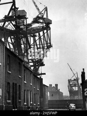 Die Häuser in Runcorn werden von der neuen Runcorn-Widnes-Brücke, die im Bau ist, in den Schatten gestellt. 19th. März 1960. Stockfoto