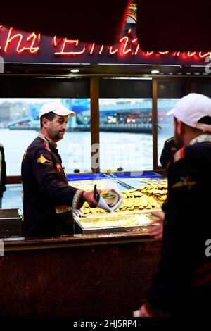 Makrelenfisch, gegrillt für die berühmten Fisch-Sandwiches, serviert von bunten Booten an der Galata-Brücke in Istanbul, Türkei. Stockfoto