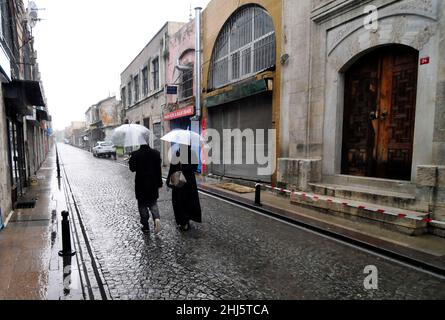 Ein türkisches Paar, das auf einer alten Kopfsteinpflasterstraße in Balat, Istanbul, Türkei, läuft. Stockfoto