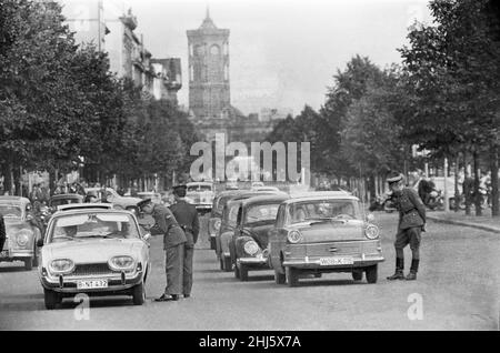 Beginn des Baus der Berliner Mauer.am 13th. August um Mitternacht begannen Polizei und Einheiten der DDR-Armee mit der Schließung der Grenze und am Sonntagmorgen, dem 13. August, wurde die Grenze zu West-Berlin geschlossen. Ostdeutsche Truppen und Arbeiter hatten begonnen, Straßen entlang der Grenze zu zerreißen, um sie für die meisten Fahrzeuge unpassierbar zu machen und Stacheldraht-Verstrickungen und Zäune entlang der 156 Kilometer um die drei westlichen Sektoren sowie der 43 Kilometer, die West und Ost trennten, zu installieren Berlin. Das Bild zeigt: Die DDR-Polizei überprüft die Fahrerdokumentation auf der St. Stockfoto