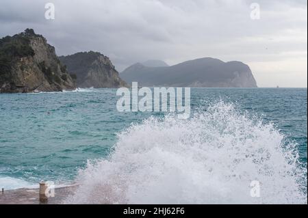 Große Welle planschen auf Pier. Meereswelle brechen auf Pier. Wellen krachen über Wellenbrecher. Wellen und Sturm auf dem Meer. Winter an der adria Stockfoto