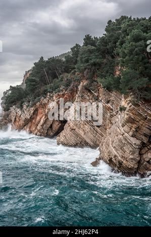Schöner Blick auf die Adriaküste an einem bewölkten Wintertag. In der Nähe der Stadt Petrovac, Adriaküste von Montenegro. Vertikales Bild Stockfoto