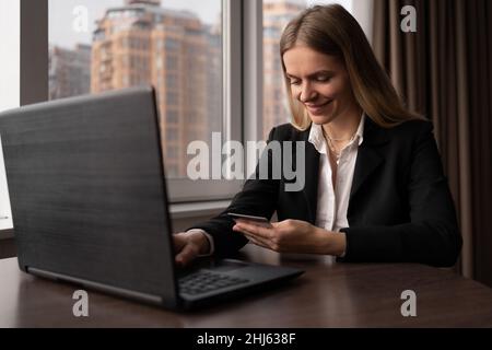 Glückliche Geschäftsfrau Online-Shopping mit Laptop im Büro. kaukasische Frau Lifestyle Online-Shopping. Bestellung von Waren und Bezahlung mit Karte vor Ort. Stockfoto