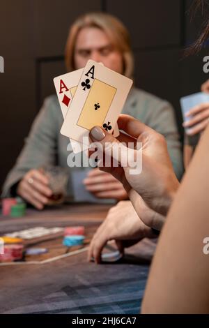 Zwei Asse in der Hand einer Frau, die am Spieltisch Poker spielt Stockfoto