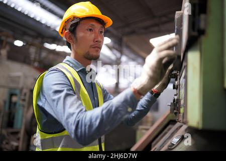 Männlicher Ingenieur Metallarbeiter Industrie erfahrene Bediener Techniker Arbeiter in Sicherheit harten Helm arbeiten an Drehmaschine, professioneller Mann in indust Stockfoto