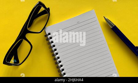 Draufsicht auf leeres Notizbuch mit Brille und Stifthintergrund. Geschäftskonzept. Stockfoto