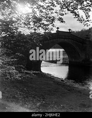 Aray Bridge, unter der sich der Fluss Aray und Loch Fyne treffen. Durch den Bogen der alten Brücke kann Loch Fyne in seiner ganzen Pracht mit dem verspiegelten Inveraray an seinen Ufern gesehen werden. Argyll and Bute, Schottland, 7th. November 1956. Stockfoto