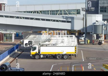 Lastwagen, die vor dem Abflug in einer Reihe geparkt wurden, die speziell für die Enteisung von Flugzeugen ausgestattet war Stockfoto