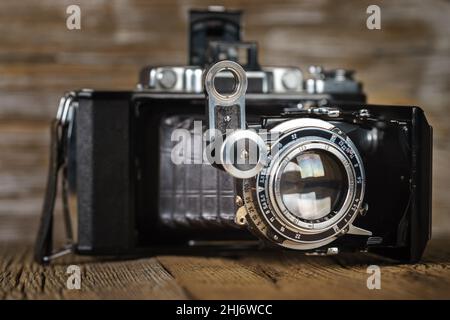 Alte falten Kamera auf eine strukturierte Holzmöbeln im Landhausstil Oberfläche Stockfoto