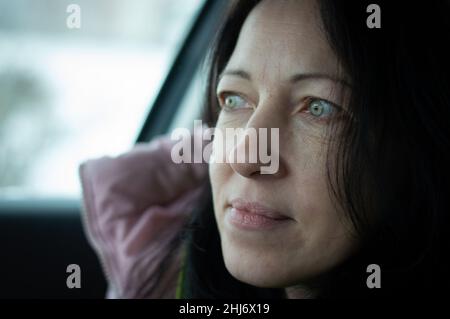 Glückliche Frau, die im Auto sitzt und lächelt. Glückliche Menschen Stockfoto