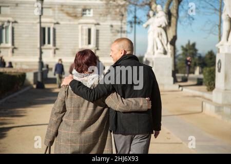 Ältere kaukasische Männer und Frauen gehen Arm in Arm Stockfoto