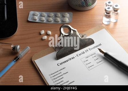 Krankenakte für Coronavirus covid-19 auf einem Schreibtisch mit Pillen-Fläschchen und einer Spritze Stockfoto
