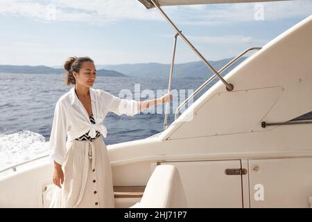 Frau auf weißer Yacht im Meer während der Sommerferien Stockfoto