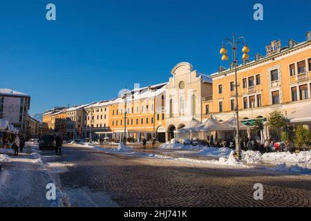 Belluno, Italien - Dez 11 2021. Dezember Schnee in einer historischen Straße in der nordöstlichen italienischen Stadt Belluno, Region Venetien. Auf der Piazza dei Martiri Stockfoto