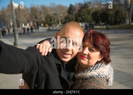 Ein älteres kaukasisches Paar, das auf der Straße ein Handy-Foto von sich selbst gemacht hat Stockfoto