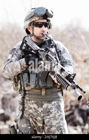 Krieger des Krieges. Ein Soldat, der mit einer Waffe in der Hand in einer Wüstenumgebung steht. Stockfoto