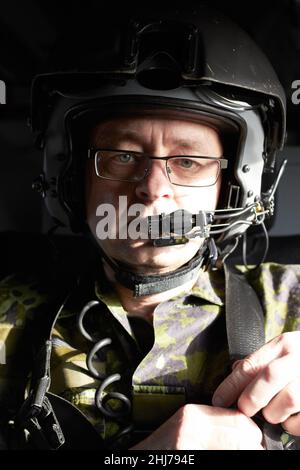 Luft zu Boden rufen Porträt eines Piloten in seinem Flugzeug, der einen Helm mit einem Kommunikationsgerät trägt. Stockfoto