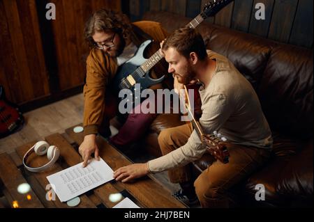 Instruktor, der Mann unterrichtet, spielt zu Hause Gitarre Stockfoto