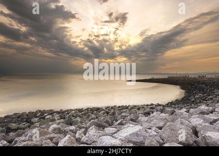 Sonnenuntergang über der Morecambe Bay mit der Küstenlinie, die sich in die Ferne schweigt Stockfoto