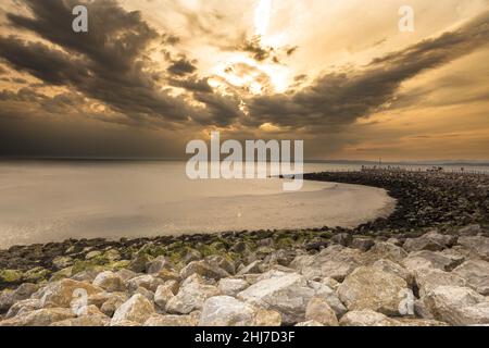 Sonnenuntergang über der Morecambe Bay mit der Küstenlinie, die sich in die Ferne schweigt Stockfoto