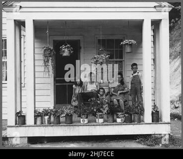 T. J. Martin, Bergmann und Familie auf der Veranda ihres Hauses. Herr Martin kam vor 13 Monaten hierher. Hat genug gesparten... - Stockfoto