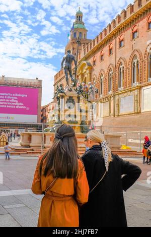 Bologna, Italien: Zwei junge Frauen in stilvoller Kleidung auf dem Stadtplan in der Nähe des Neptunbrunnens auf dem Platz Piazza Maggiore Stockfoto