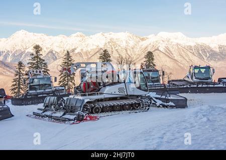 Parken auf einer Piste Schneeräumgeräte für ein Skigebiet. Schneepflügen Bulldozer Grooming für Ski- und Snowboardurlaub am Berg Stockfoto