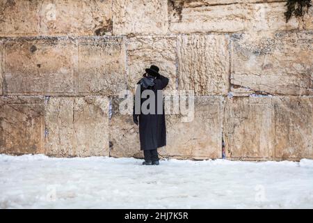 Jerusalem, Israel. 27th Januar 2022. Ein ultra-orthodoxer jüdischer Mann betet nach einem Schneesturm an der Westmauer, die im Islam als Buraq-Mauer bekannt ist. Quelle: Ilia Yefimovich/dpa/Alamy Live News Stockfoto