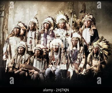 Kleine Wunde und neun weitere Sioux-Häupter tragen Federkopfschmuck und traditionelle Accessoires. indianisch/indianisch. Dakota. Foto von Heyn. Stockfoto