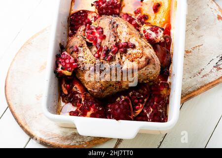 Appetitliches Stück Schweinelende in einer fruchtigen Marinade. Gebratenes Fleisch mit Granatapfel in Backform Stockfoto