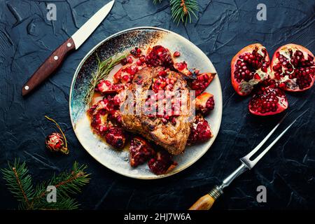 Stück Schweinelende in einer fruchtigen Marinade. Gebratenes Fleisch mit Granatapfel. Weihnachtliches Essen Stockfoto