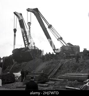 1967, historisch, ein Eisenbahnabzug, Arbeiter vor Ort und Greifkrane, die einen Eisenbahnwagen von der Gleisstrecke in hither Green, South London, England, Großbritannien, bewegen. In der Nähe des Wartungsdepots von „hither Green“ wurden zwölf Reisebusse wegen eines kaputten Gleis entgleist. Stockfoto