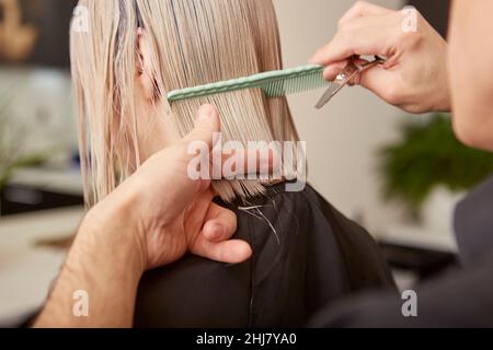 Friseur Kämmen und Schneiden Frau Haare im Schönheitssalon Stockfoto