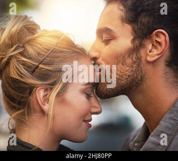 Sie ist so besonders für mich. Kurzer Schuss eines jungen Mannes, der die Stirn seiner Freundin küsst. Stockfoto